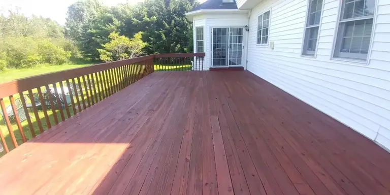 Deck stained deep red along a white colonial home, deck staining in Avon Lake, Ohio