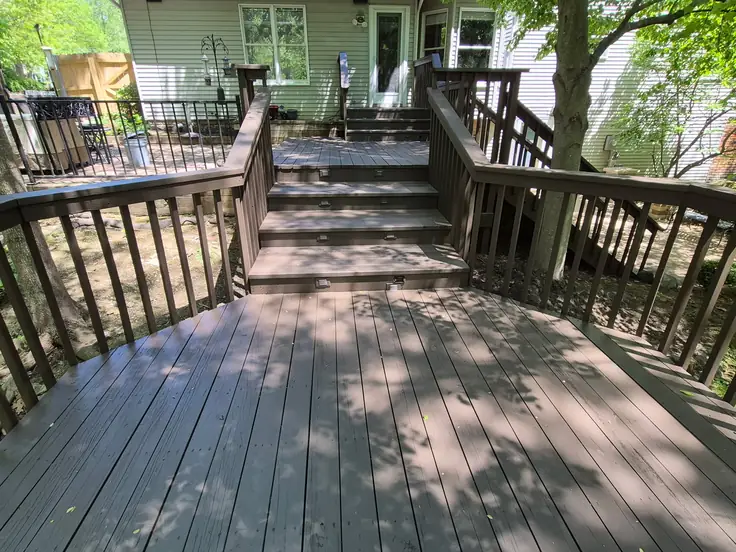 Multi level deck with fresh solid brown stain in dappled summer shade