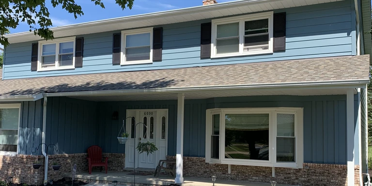 Blue two-story colonial with white trim and black shutters after exterior painting in Willoughby Hills, Ohio
