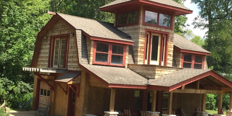 Cedar shake home with red trim after siding staining in Auburn, Ohio
