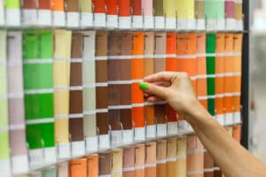 A person selecting from a variety of paint swatches, planning a DIY painting project.