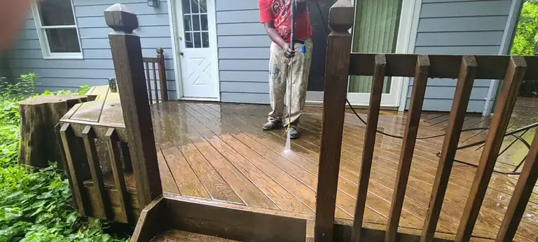 Crew member power washing a wood deck before staining, Northeast Ohio