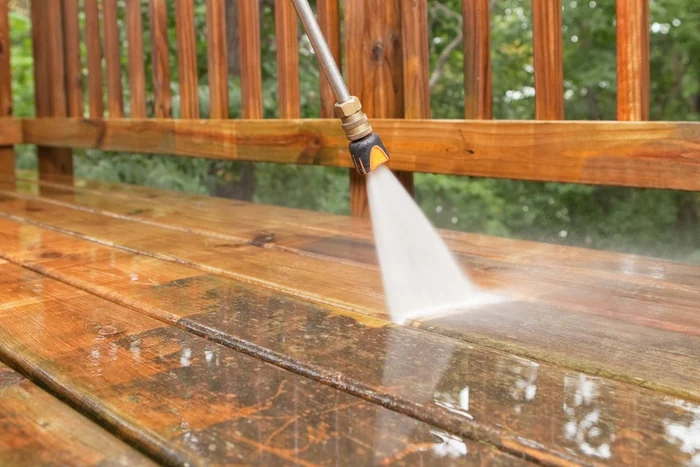 Pressure washing wand stripping dirt from a wood deck in Beachwood, Ohio
