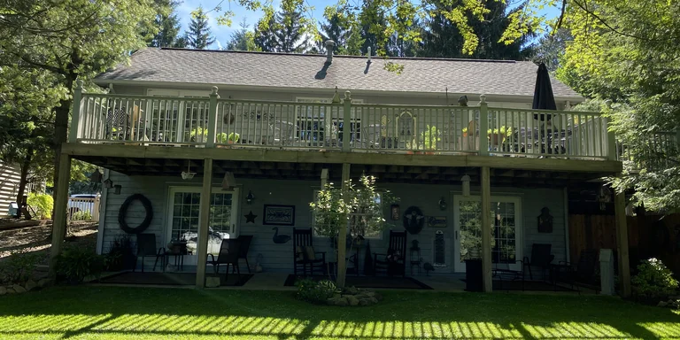 Two-level rear deck with a white railing over a covered patio in Willoughby Hills, Ohio