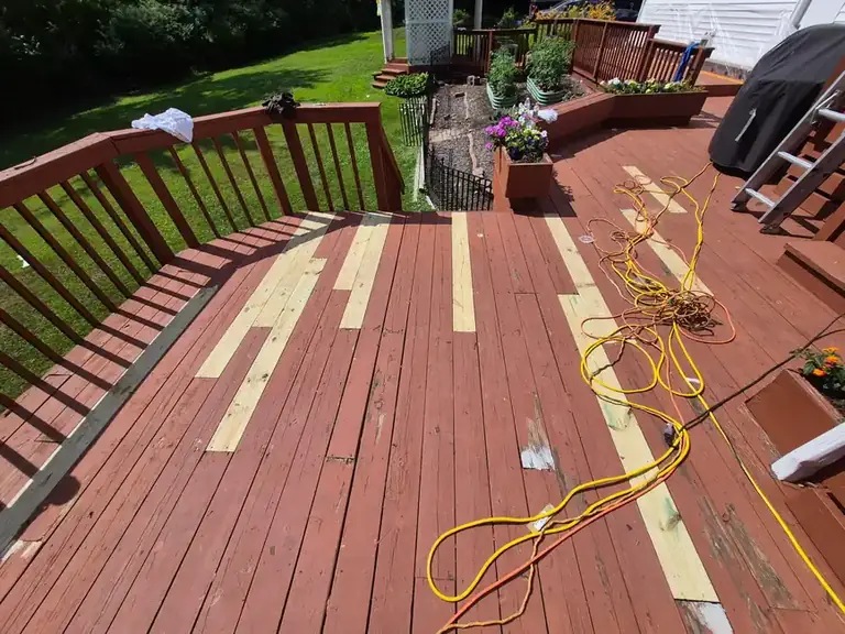New replacement boards installed on a red deck before staining, deck repair in Northeast Ohio