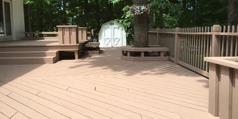 Multi-level deck with built-in benches after a solid tan stain in Novelty, Ohio