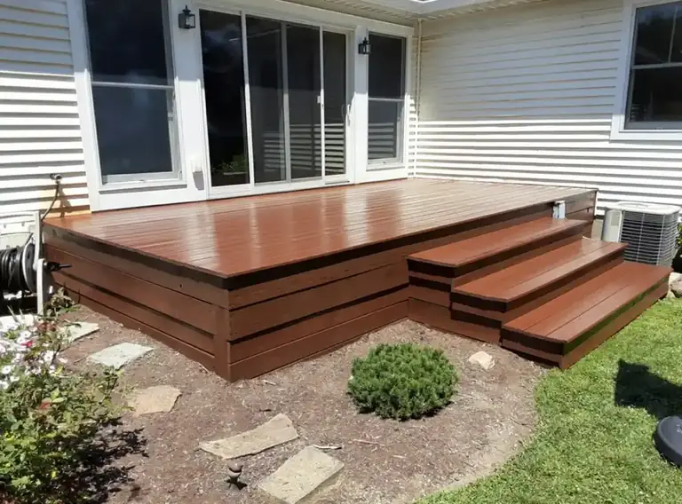 Deck stained a rich red-brown with matching steps beside a white house, deck staining in Fairview Park, Ohio