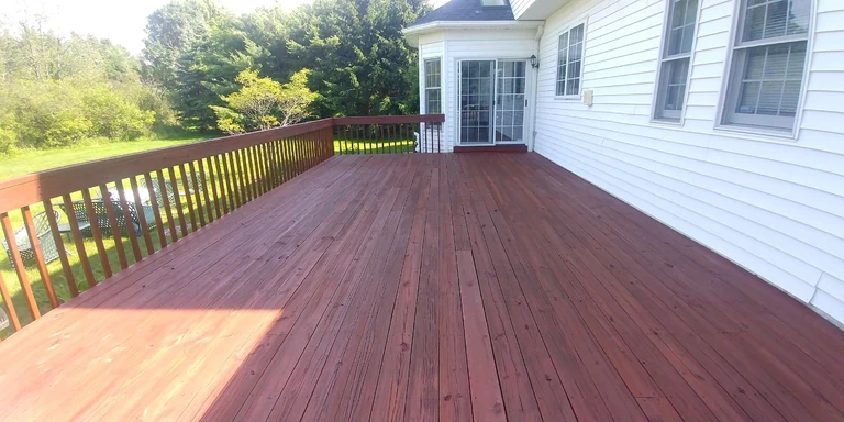 Large backyard deck with railings after a red-brown stain in South Russell, Ohio