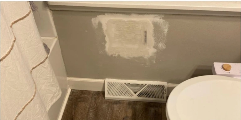 Bathroom wall patched with joint compound where an old fixture was removed, before paint, Northeast Ohio home