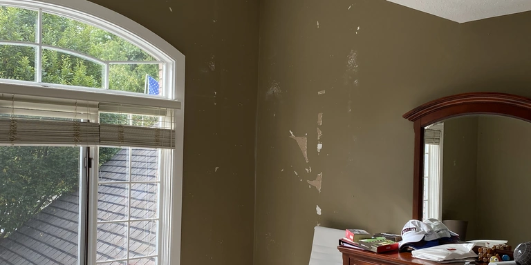 Scraped and patched bedroom wall being prepped for repaint in a Northeast Ohio home