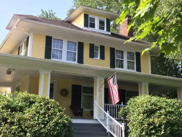 Yellow house with fresh paint and complementary dark shutters.