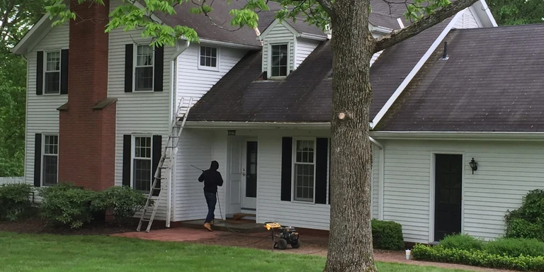 Crew pressure washing the front of a white colonial before painting in Moreland Hills, Ohio