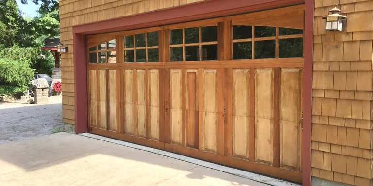 Cedar-shake garage door and concrete apron after power washing in Auburn, Ohio