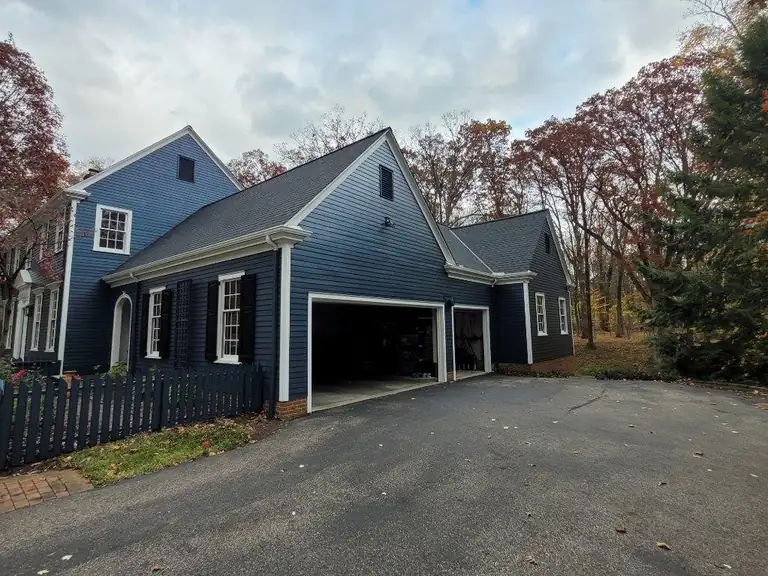 Two-story home with freshly painted navy siding, white trim and black shutters, exterior color change in Northeast Ohio