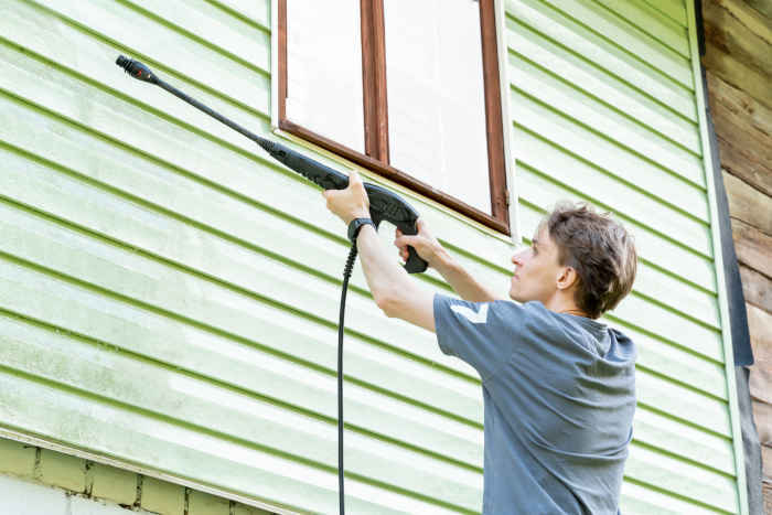 High-powered pressure washer tackling tough grime on home exteriors.