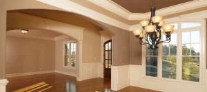Formal living room with warm tan walls, white wainscoting, tray ceiling, and hardwood floors representing house painting services in Highland Heights, Ohio by Chagrin Falls Painting Company