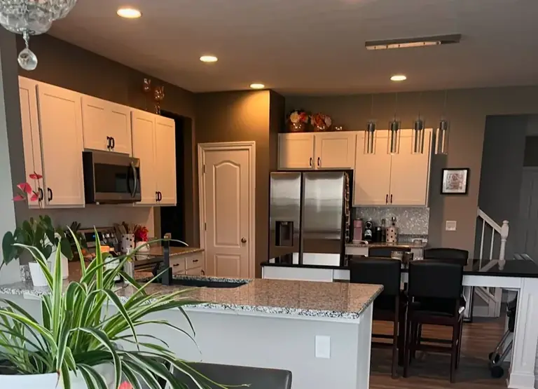 Full kitchen with refinished white cabinets and stainless appliances, cabinet refinishing in Parma, Ohio