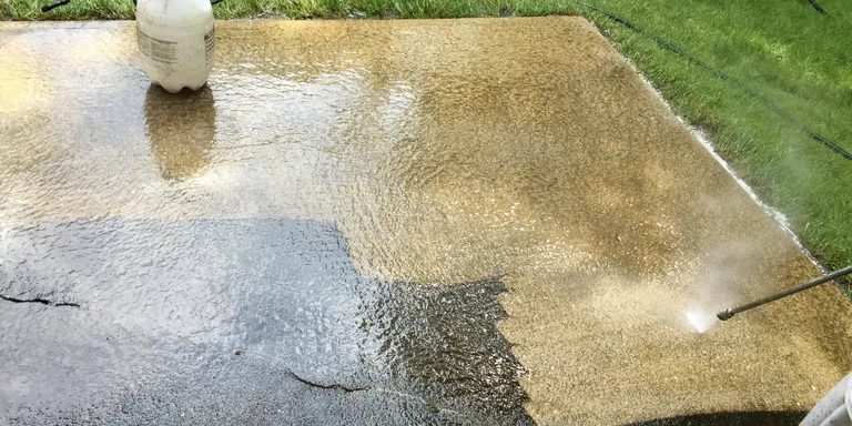 Exposed-aggregate patio half cleaned mid-wash, patio pressure washing in Chardon, Ohio