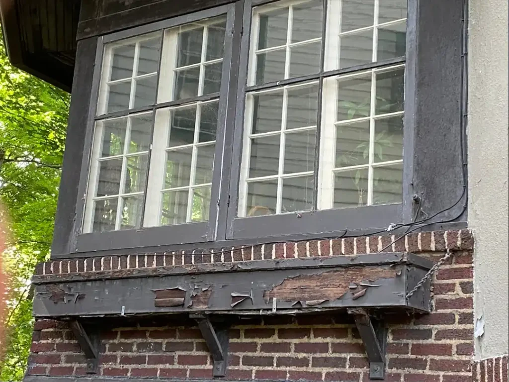 Peeling and flaking paint on window trim showing coating system failure - sign your Northeast Ohio home needs exterior painting