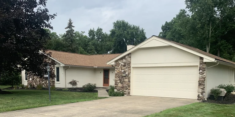 Cream ranch home with stone accents and a two-car garage after exterior painting in Twinsburg, Ohio