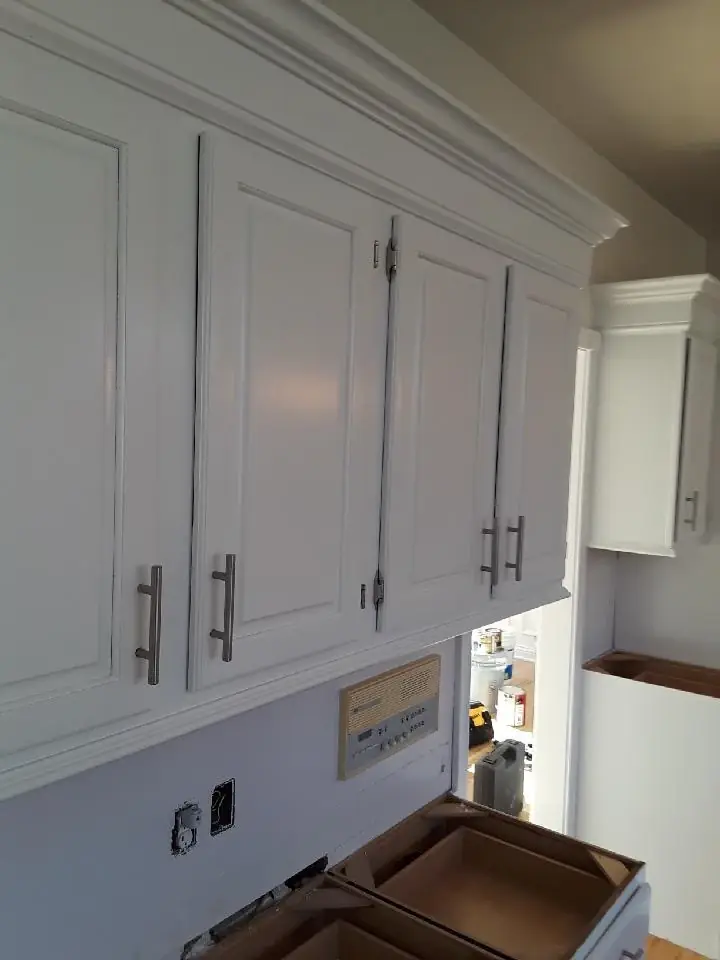 Refinished white upper cabinets with brushed nickel handles and crown molding, Northeast Ohio