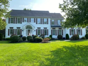 Brown shutters on white colonial home painted by Chagrin Falls Painting Company, Ohio