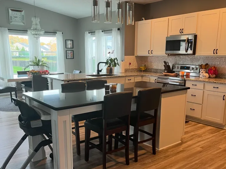 Refinished white kitchen cabinets with a black-topped island, cabinet refinishing in Parma, Ohio