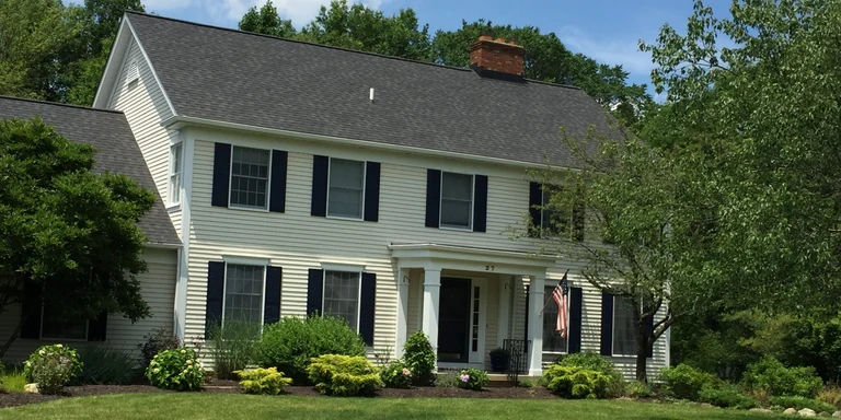 White colonial with navy shutters after exterior painting in Chagrin Falls, Ohio