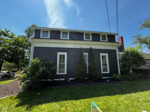 White window trim on dark gray lap siding home by Chagrin Falls Painting Company