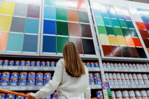 A woman in the Home Depot paint aisle browsing options.